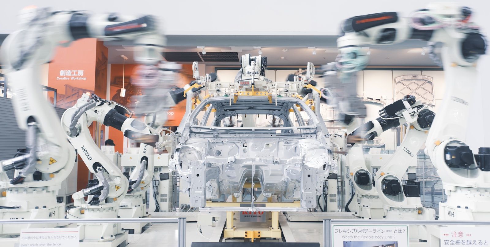 Industrial robotic arms assembling a car chassis on a factory line